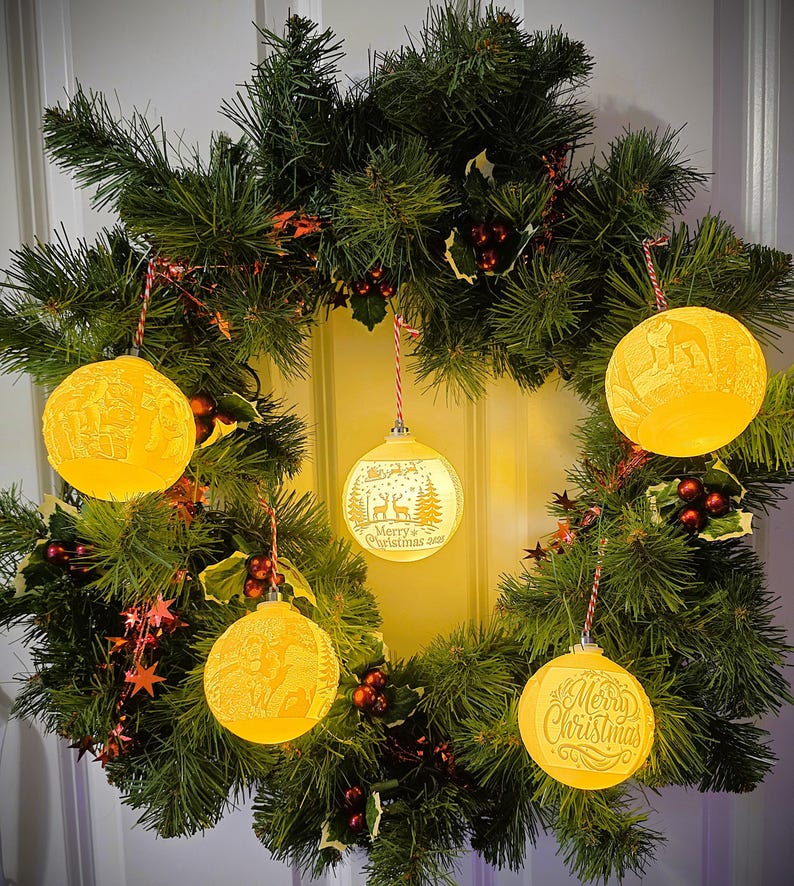 Custom glowing photo lithophane Christmas ornaments displayed on a festive wreath